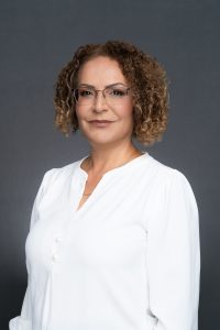 Studio headshot of Majeda Awawdeh against a plain grey background.