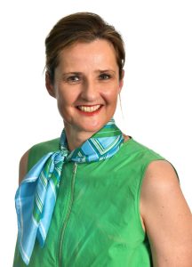 Studio portrait of Carolyn Holbrook smiling at the camera against a plain white background.