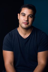 Studio portrait of Marc Fennell with a small smile looking at the camera.